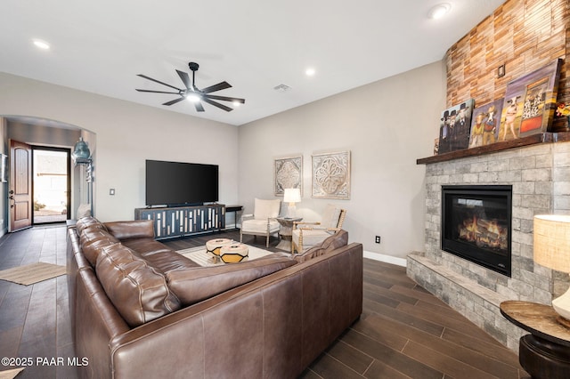 living room with ceiling fan, a fireplace, and dark hardwood / wood-style floors