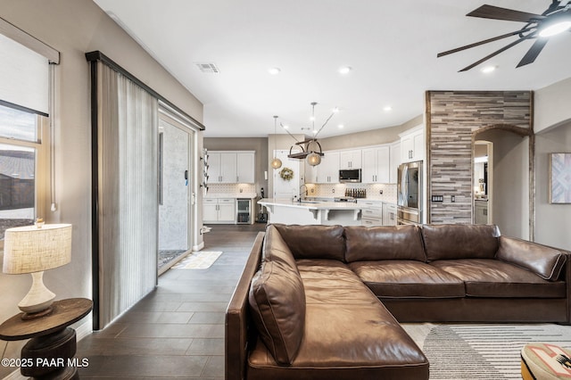 living room featuring dark hardwood / wood-style flooring, sink, and ceiling fan