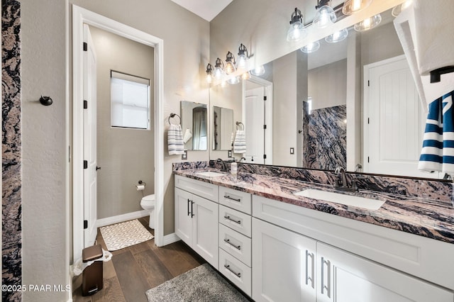 bathroom with wood-type flooring, vanity, and toilet