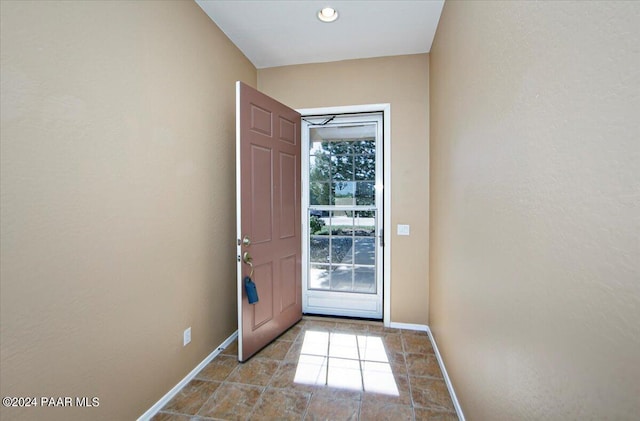 doorway to outside with baseboards