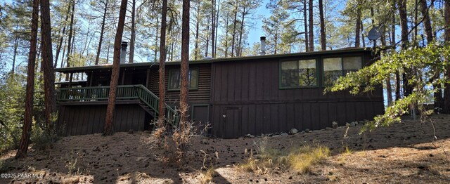 exterior space with log veneer siding and stairway