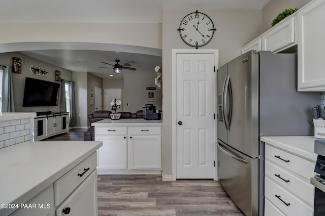 kitchen featuring white cabinetry, ceiling fan, wall oven, light hardwood / wood-style flooring, and stainless steel fridge