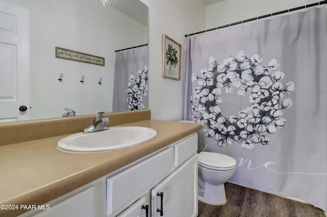 bathroom featuring wood-type flooring, vanity, and toilet