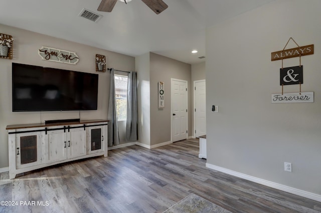 unfurnished living room featuring wood-type flooring and ceiling fan