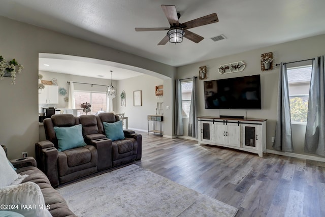 living room featuring light hardwood / wood-style flooring and ceiling fan with notable chandelier