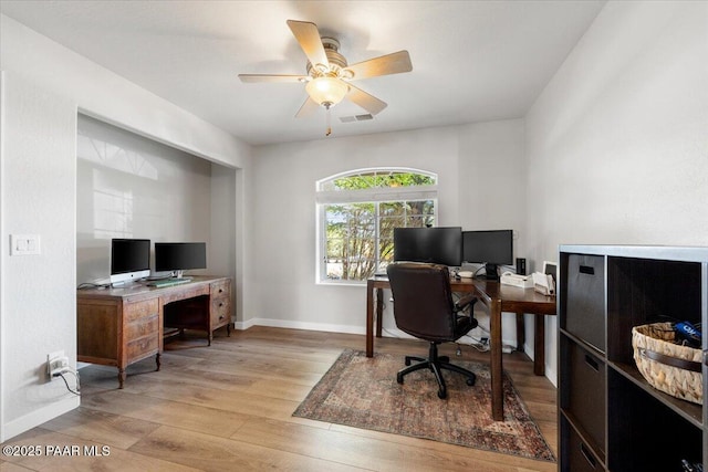 office featuring a ceiling fan, baseboards, visible vents, and light wood-style flooring