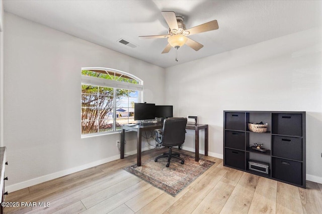 home office featuring baseboards, a ceiling fan, wood finished floors, and visible vents