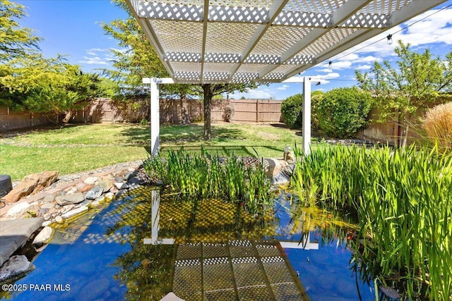 exterior space with a small pond, a pergola, and a fenced backyard