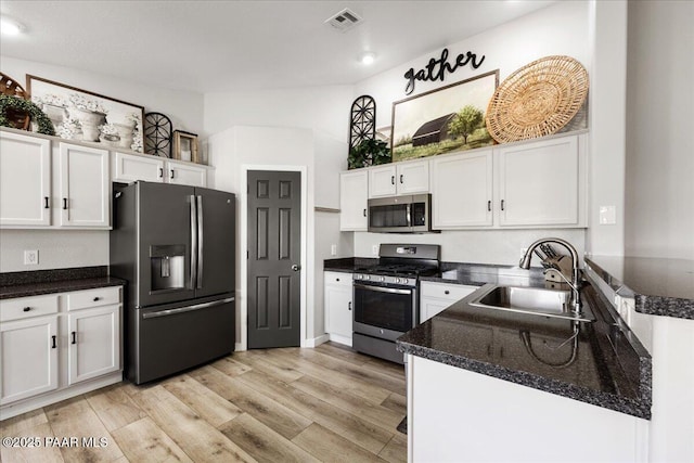 kitchen with visible vents, a sink, white cabinetry, and appliances with stainless steel finishes