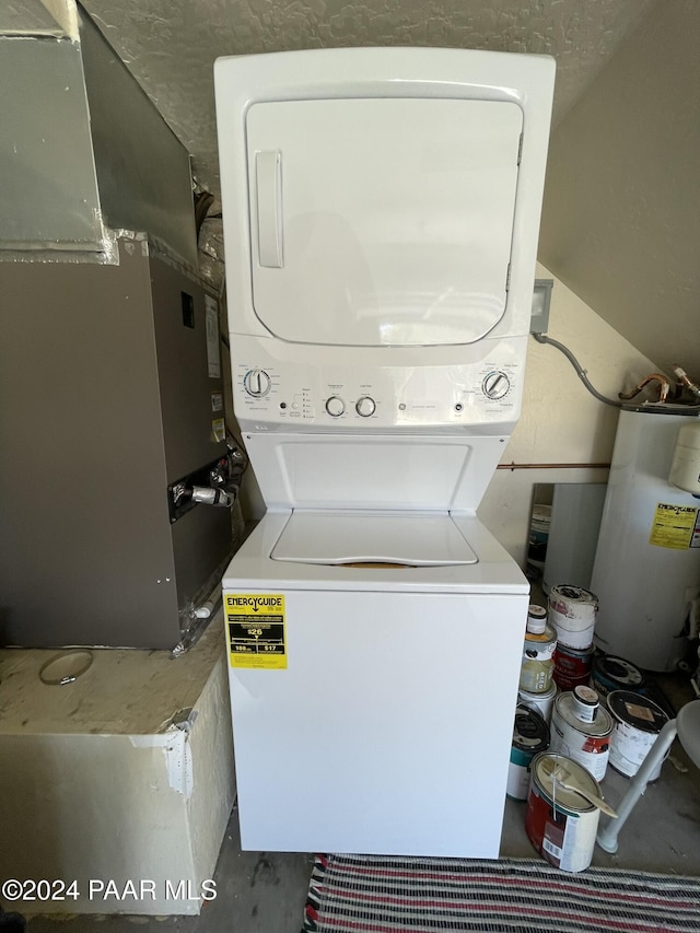 laundry room with heating unit, gas water heater, and stacked washer / drying machine