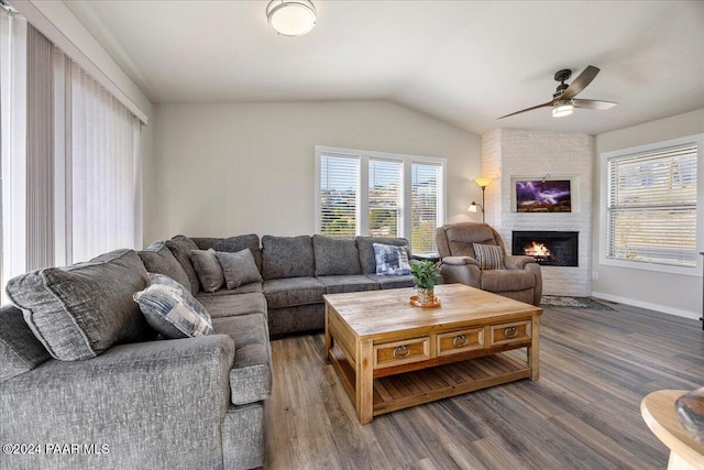 living room with hardwood / wood-style flooring, ceiling fan, lofted ceiling, and a fireplace