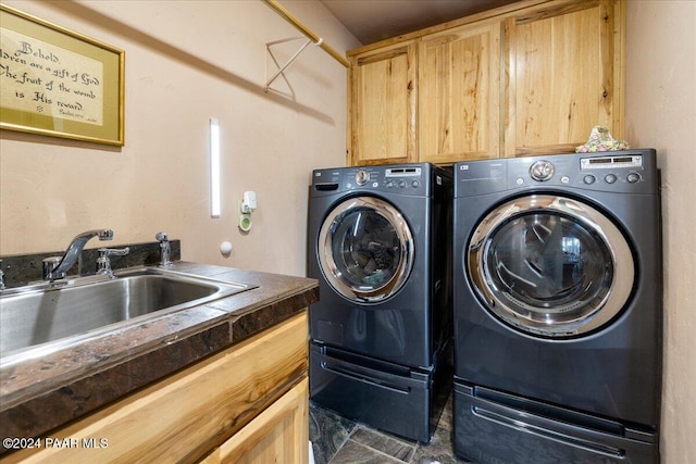 clothes washing area with cabinets, independent washer and dryer, and sink