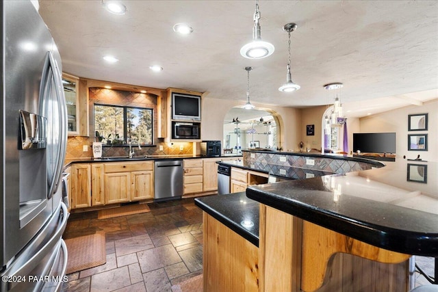 1568 W Thumb Butte Rd, Prescott, AZ 86305 - kitchen featuring appliances with stainless steel finishes, arched walkways, recessed lighting, healthy amount of natural light, and stone tile flooring