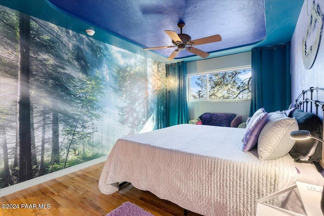 bedroom with wood-type flooring and ceiling fan