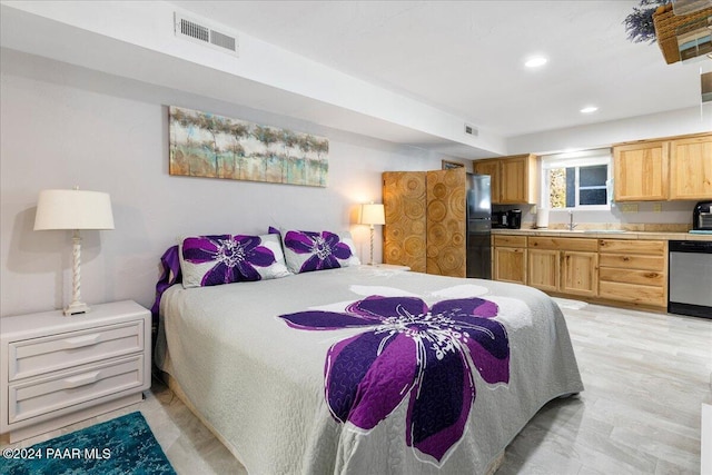 bedroom with black refrigerator and sink