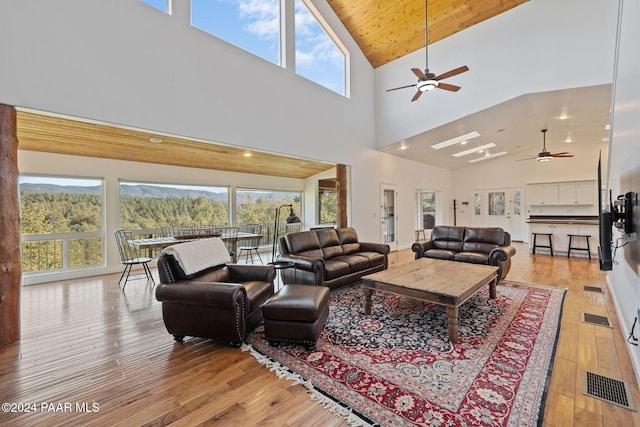 living room featuring ceiling fan, a healthy amount of sunlight, and light wood-type flooring