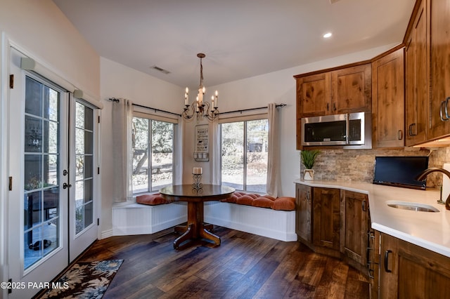 dining space featuring sink, dark hardwood / wood-style floors, plenty of natural light, and a chandelier