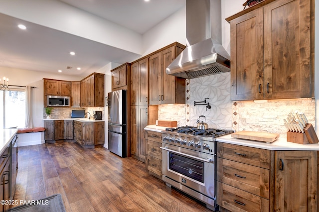 kitchen featuring appliances with stainless steel finishes, extractor fan, backsplash, dark hardwood / wood-style floors, and a notable chandelier