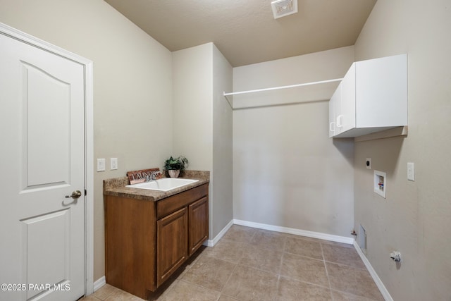 washroom with light tile patterned floors, sink, hookup for a washing machine, electric dryer hookup, and cabinets