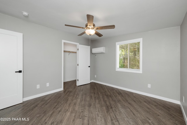 unfurnished bedroom featuring dark hardwood / wood-style flooring, ceiling fan, and a wall mounted air conditioner