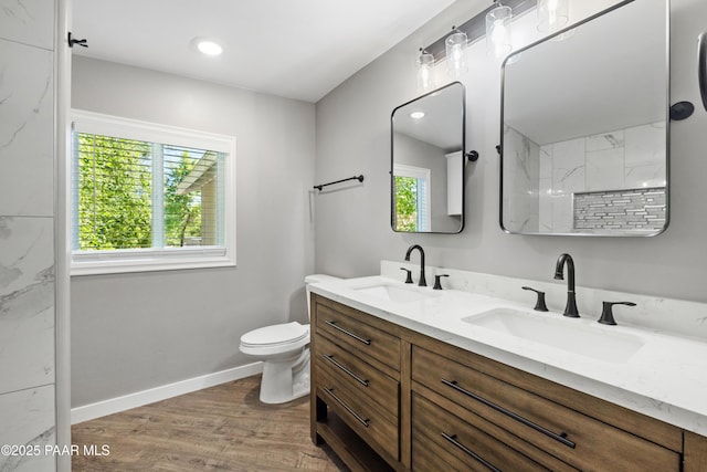 bathroom with toilet, hardwood / wood-style flooring, a wealth of natural light, and vanity