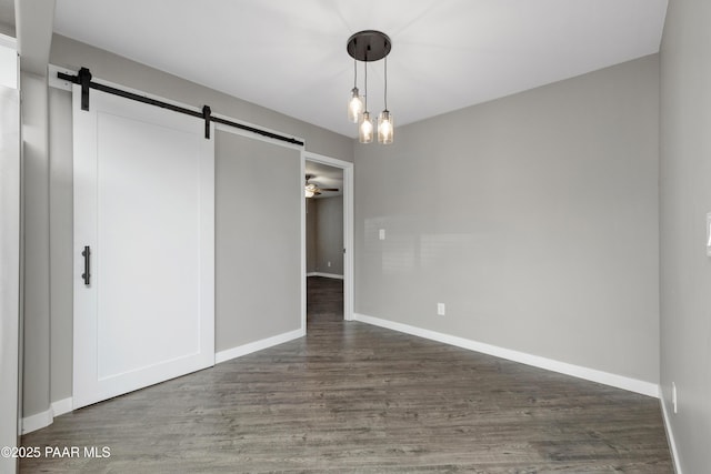 unfurnished bedroom with a closet, a barn door, and dark hardwood / wood-style flooring