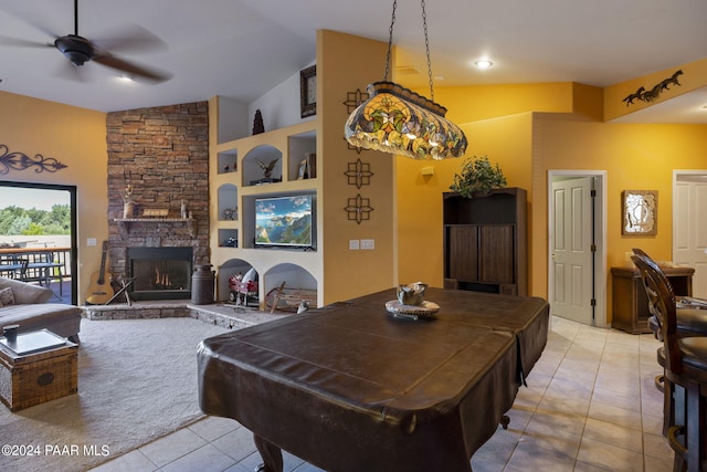 tiled dining area with ceiling fan, built in shelves, vaulted ceiling, and a fireplace