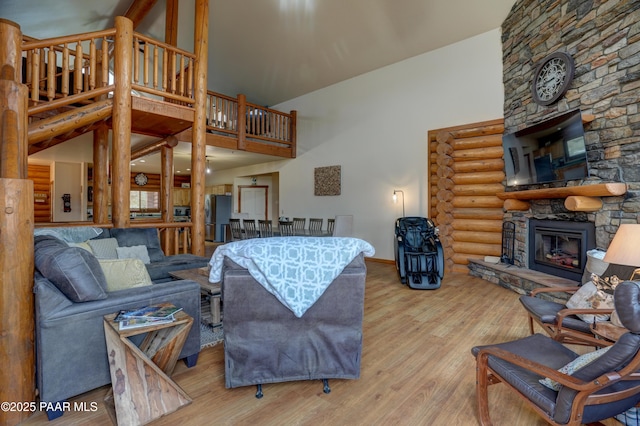 1070 Quiet Pines Ln, Prescott, AZ 86303 - living room featuring high vaulted ceiling, a stone fireplace, rustic walls, and wood finished floors