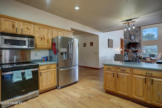 1070 Quiet Pines Ln, Prescott, AZ 86303 - kitchen featuring appliances with stainless steel finishes, light wood-style flooring, a stone fireplace, and pendant lighting