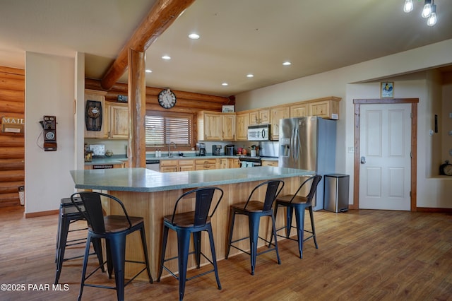 1070 Quiet Pines Ln, Prescott, AZ 86303 - kitchen featuring appliances with stainless steel finishes, rustic walls, light brown cabinetry, recessed lighting, and light wood finished floors