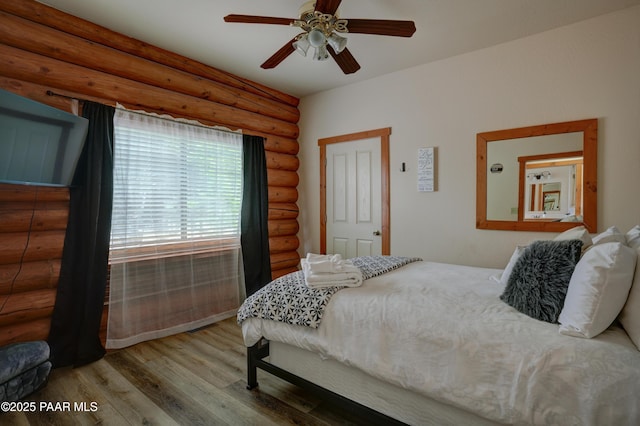 1070 Quiet Pines Ln, Prescott, AZ 86303 - bedroom featuring log walls, wood finished floors, and a ceiling fan