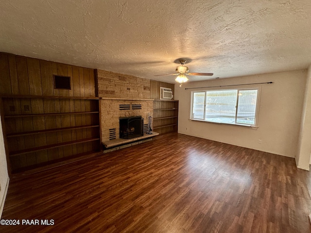 unfurnished living room with a fireplace, ceiling fan, dark hardwood / wood-style flooring, and a textured ceiling