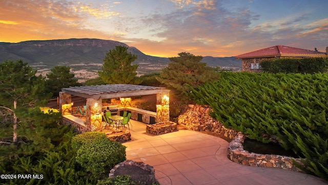 12390 E Triple T Ln, Prescott Valley, AZ 86315 - patio terrace at dusk with a mountain view and a pergola