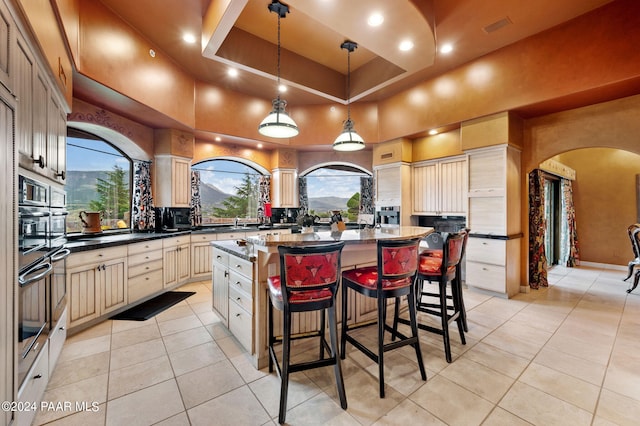 12390 E Triple T Ln, Prescott Valley, AZ 86315 - kitchen featuring hanging light fixtures, light tile patterned floors, a towering ceiling, cream cabinetry, and a kitchen island