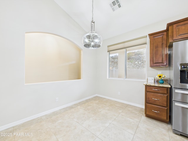 15606 E Sterling Spur Rd, Dewey-Humboldt, AZ 86327 - kitchen featuring light stone counters, vaulted ceiling, visible vents, light tile patterned flooring, and stainless steel fridge