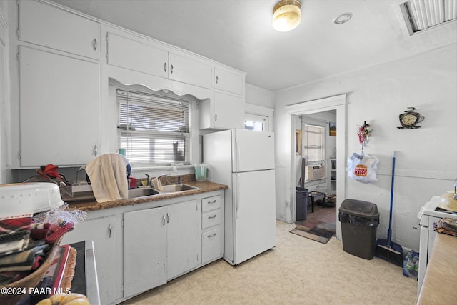 kitchen with white appliances, sink, and white cabinets