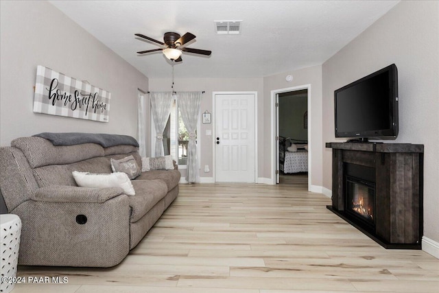 living room with ceiling fan and light wood-type flooring