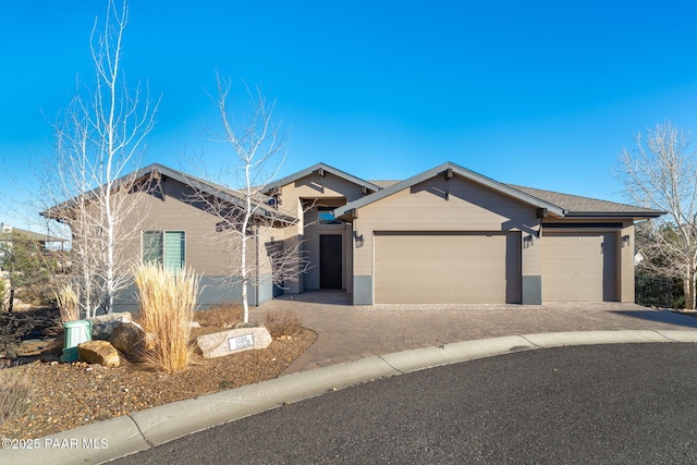 single story home featuring decorative driveway and an attached garage