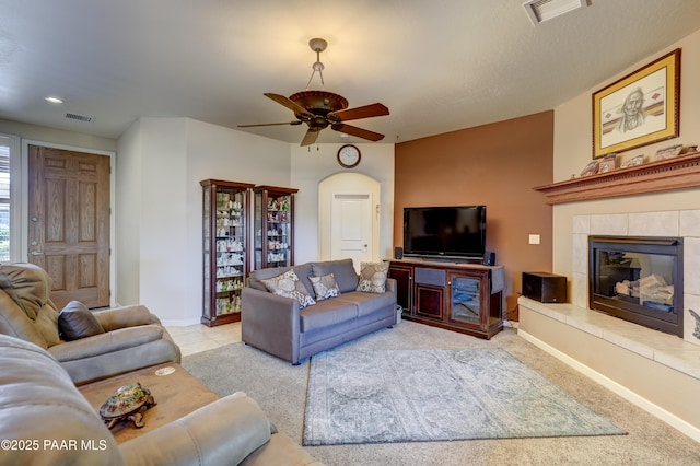 3096 Adobe Springs Dr, Prescott, AZ 86301 - carpeted living area featuring a ceiling fan, a tile fireplace, and arched walkways