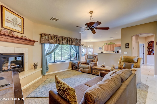 3096 Adobe Springs Dr, Prescott, AZ 86301 - living area with arched walkways, a ceiling fan, a tiled fireplace, light tile patterned flooring, and recessed lighting