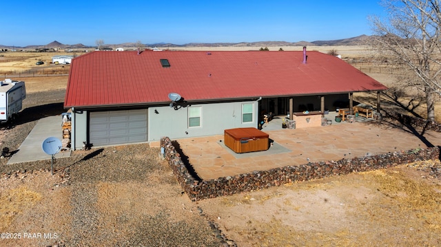 7889 E Dog Ranch Rd, Prescott Valley, AZ 86315 - rear view of house with a hot tub, a mountain view, a patio area, metal roof, and stucco siding