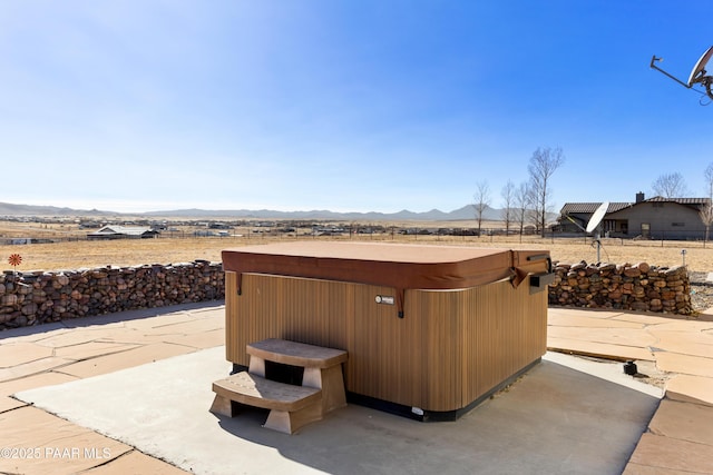 view of patio featuring a mountain view and a hot tub