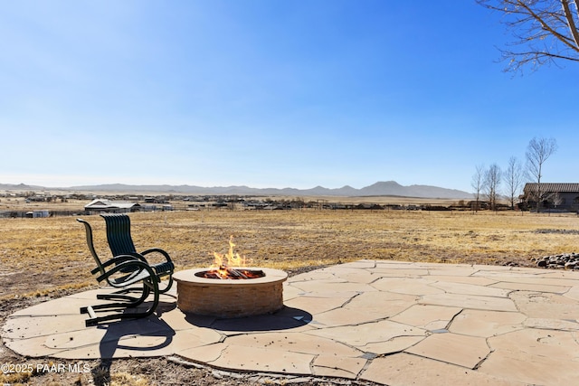 view of patio / terrace featuring a fire pit and a mountain view