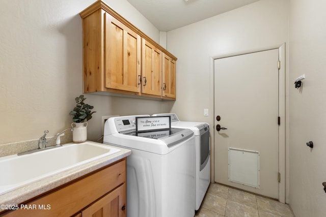 laundry area with cabinets, sink, washing machine and dryer, and light tile patterned flooring