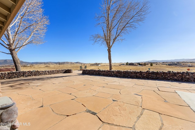 view of patio / terrace with a mountain view and a rural view