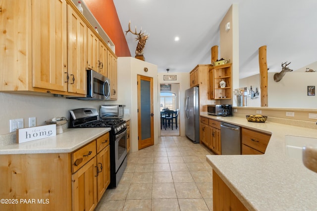 kitchen featuring sink, kitchen peninsula, appliances with stainless steel finishes, and light tile patterned flooring