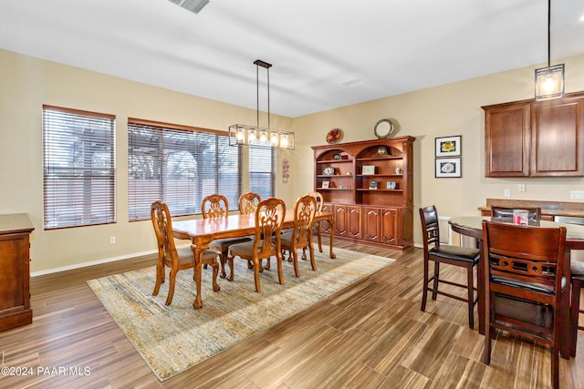 dining area featuring dark hardwood / wood-style flooring and an inviting chandelier