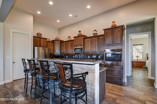 892 Canyon Breeze Ct, Prescott, AZ 86303 - kitchen with a kitchen island, stainless steel appliances, wood finished floors, and a breakfast bar area
