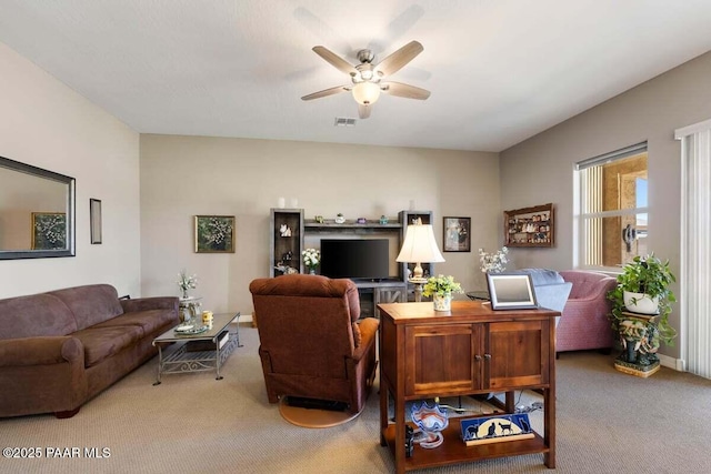 carpeted living room with ceiling fan