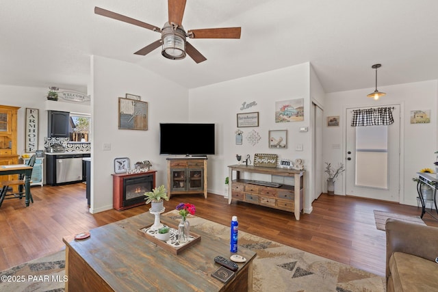 living room featuring ceiling fan, vaulted ceiling, and wood finished floors